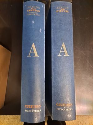 two blue books sitting on top of a table next to each other