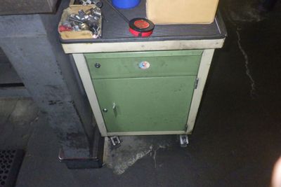 une armoire verte avec une plaque de cuisson et un seau bleu