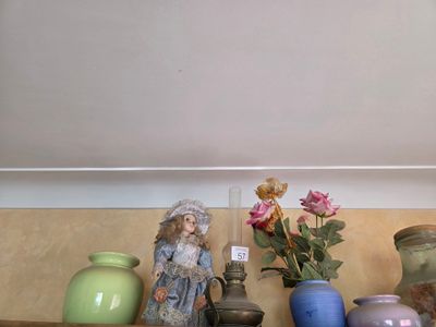 une étagère sur laquelle sont posés des vases et une statue représentant une femme