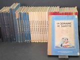 Plusieurs livres sont empilés les uns sur les autres devant un fond noir.