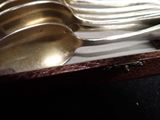 silver spoons and forks in a box on a table