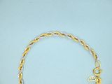 gold and silver bracelet with a fish charm on a blue background