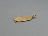 a close up of a gold plated pendant on a gray surface