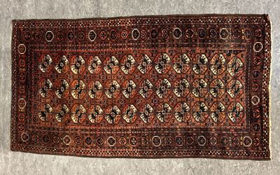 Un vieux tapis est posé par terre près d'un mur.