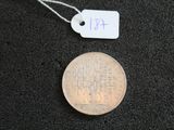 une pièce de monnaie sur laquelle est apposée une étiquette de prix, posée sur une surface noire