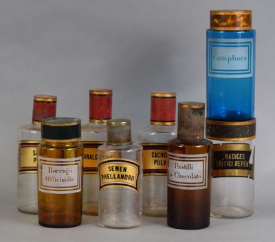Des flacons contenant différents types de médicaments sont alignés sur une surface blanche