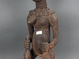 une statue en bois représentant une femme tenant un bébé dans ses bras