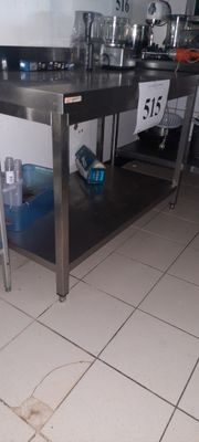 une cuisine équipée d'une table en inox et d'un évier