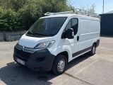 la camionnette blanche est garée sur un parking avec des arbres en arrière-plan