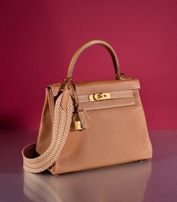 a close up of a purse on a table with a red wall in the background