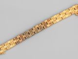 Gros plan sur un bracelet en or orné d'une croix