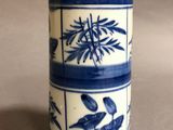 a blue and white vase with a plant design on it