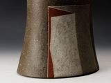 a vase that has a brown and red design on it