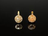 une paire de boucles d'oreilles en or et diamants sur une surface noire