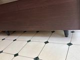 tiled floor in a kitchen with a wooden cabinet and black and white checkered floor