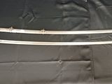 une image représentant une paire d'épées posées sur un tissu noir