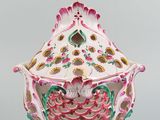 a white vase with a pink and green design on it