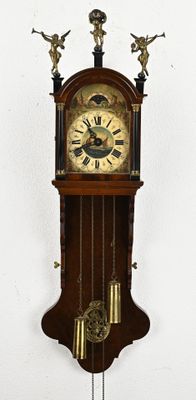 a clock that is hanging on the wall with angels on it