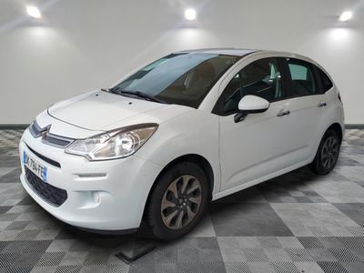 la petite voiture blanche est garée sur un sol en damier