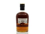 a bottle of whisky sitting on top of a white surface