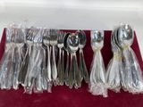 a lot of silverware sitting on a red table cloth