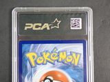 a pokemon card in a plastic case on a table