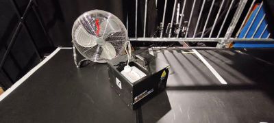 un ventilateur posé sur une table devant une clôture