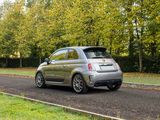 a small silver car driving down the road
