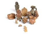many pieces of pottery that are sitting on a white surface
