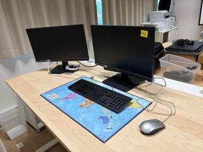 deux écrans d'ordinateur posés sur un bureau, avec une souris et un clavier