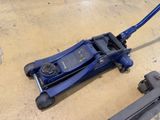 a blue jack sitting on the floor next to a pair of clamps