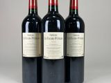 three bottles of red wine sitting on top of a white table