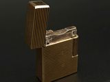 un briquet doré posé sur une surface noire