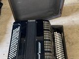 a black accordion sitting in a case on the floor