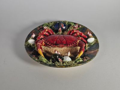 une assiette posée sur une table, sur laquelle se trouve un crabe