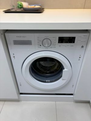 a washing machine in the corner of a kitchen