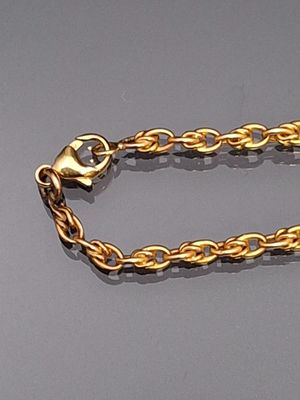 a gold chain with a heart on it on a gray surface