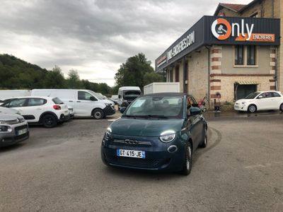 a small car parked in a parking lot in front of a building