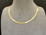 un collier plaqué or autour du cou d'un mannequin