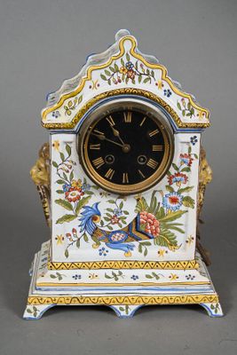 une horloge posée sur un socle orné d'un oiseau