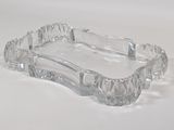 a clear glass ashtray sitting on a white surface