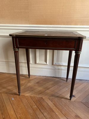 une petite table en bois avec un plateau en marbre, posée sur un parquet en bois massif