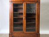 an antique oak bookcase with glass doors and shelves
