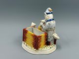une figurine représentant un homme assis sur une boîte