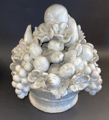 a white vase with a bunch of fruit in it
