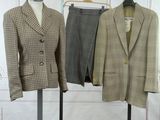 two suits on display on a rack in a room