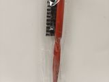 a red toothbrush in a plastic bag on a white surface