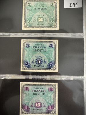 Trois types différents de devises étrangères sont exposés dans une vitrine.