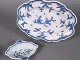 two blue and white dishes and a bowl on a stand