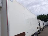 trucks parked in a parking lot with trees in the background